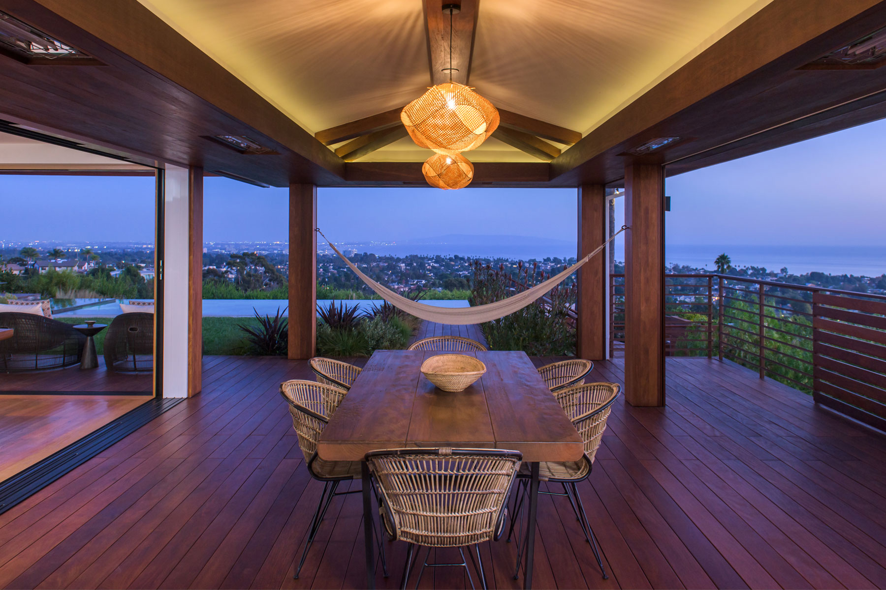 At night view of tranquil and elegant outdoor dining room wood deck and covered