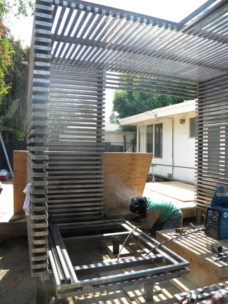 Installation of the steel enclosure for the outdoor seating area and firepit at the Joffrey Residence