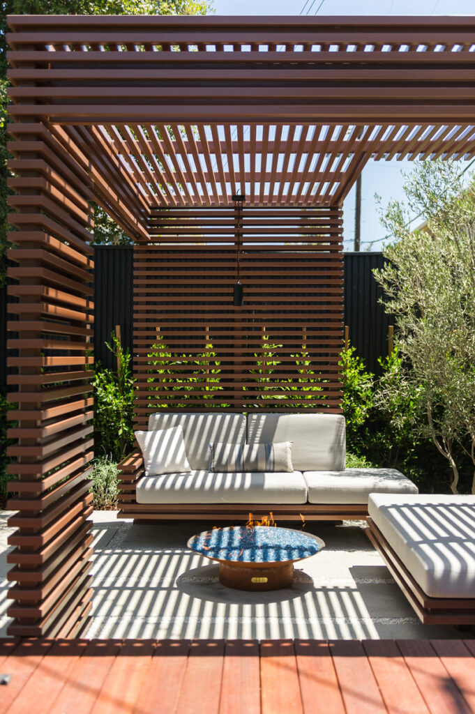 Outdoor lounge room with metal trellis enclosure for conversation and fire